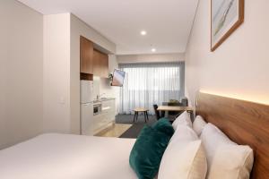 a hotel room with a bed and a kitchen at Durham Serviced Apartments in Adelaide