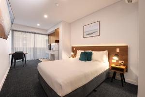 a hotel room with a bed and a desk at Durham Serviced Apartments in Adelaide +21 photos