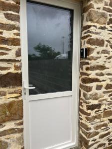a white door on a stone wall with a window at Cozy studio in Millières