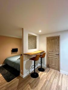 a bedroom with a bed and a desk with two chairs at Cozy studio in Millières +2 photos