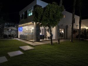 a building at night with a tree in front of it at Casa Lomas Guadalajara Jalisco in Lomas de Santa Anita