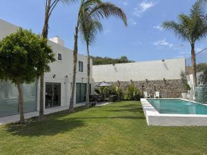 a house with a swimming pool and palm trees at Casa Lomas Guadalajara Jalisco in Lomas de Santa Anita