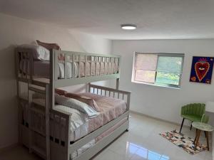 a bedroom with a bunk bed and a green chair at Casa Lomas Guadalajara Jalisco in Lomas de Santa Anita +29 photos