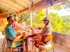 a group of people sitting around a wooden table at Wimala Farm House in Munduk