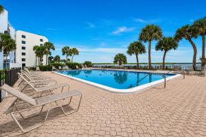 a swimming pool with lounge chairs and palm trees at Waterfront Island Oasis! Heated Pool with Stunning View & 2 Full Bath in Marco Island