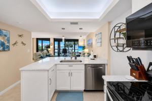 a kitchen with a sink and a microwave at Waterfront Island Oasis! Heated Pool with Stunning View & 2 Full Bath in Marco Island