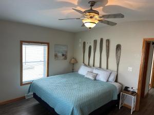 a bedroom with a bed with a ceiling fan at Mississippi River Cabin in Bellevue