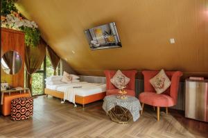 a bedroom with a bed and two chairs and a table at Up Tree Garden Đà Lạt in Xuan An