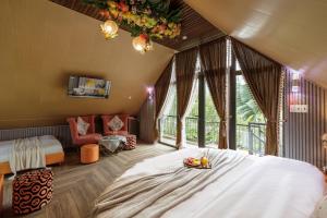 a bedroom with a large bed in a room with windows at Up Tree Garden Đà Lạt in Xuan An +59 photos