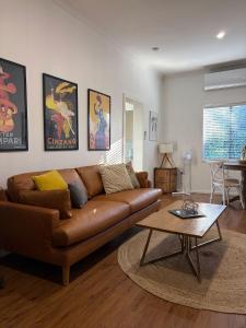 a living room with a brown couch and a table at Mary Lemon Cottage - Heritage Home in Orange +19 photos