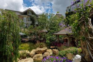 a garden with a pond in front of a house at Up Tree Garden Đà Lạt in Xuan An