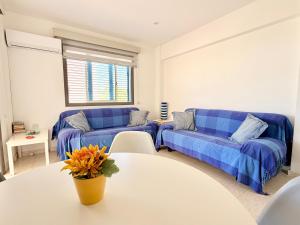 a living room with two blue couches and a table at Cozy holyday apartament in Paralimni