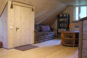 um quarto com um sofá e uma porta num sótão em Lonni Nature Eco-Accommodation em Hagudi