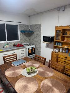 a kitchen with a wooden table with chairs and a kitchen with a stove at La Niña in Belén