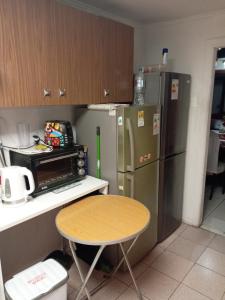 a small kitchen with a table and a refrigerator at Casa in Santiago