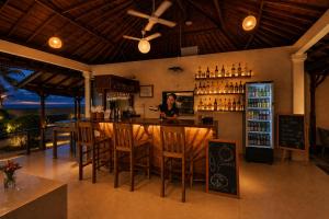 a bar in a restaurant with a woman behind the counter at Bugbug Beach Resort in Gili Biaha