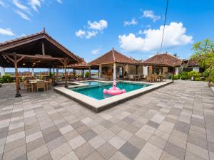 a pool at a resort with a pink float in the middle at Bugbug Beach Resort in Gili Biaha