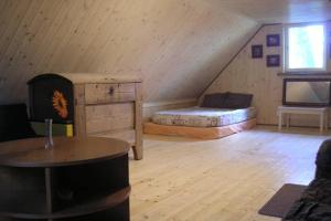 a attic room with a bed and a table at Lonni Nature Eco-Accommodation in Hagudi