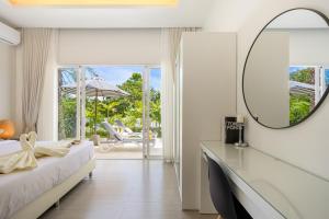 a bedroom with a mirror and a bed and a table at Villa Kiru in Koh Samui +14 photos