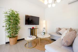 a living room with a couch and two potted plants at Villa Kiru in Koh Samui