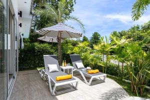 a patio with two chairs and an umbrella at Villa Kiru in Koh Samui
