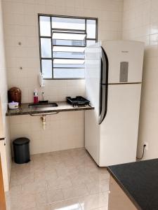 a kitchen with a white refrigerator and a window at Residencial Alice in Uberaba +4 photos