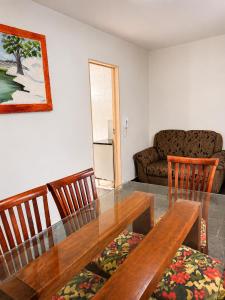 a dining room with a table and chairs and a couch at Residencial Alice in Uberaba