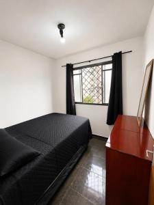 a bedroom with a bed and a dresser and a window at Residencial Alice in Uberaba