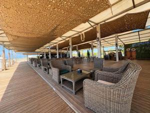 a covered deck with chairs and tables on the beach at Lemon Garden in Antalya