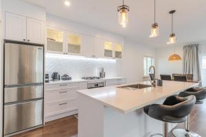 a kitchen with white cabinets and a stainless steel refrigerator at 19 Broadway in Martinborough