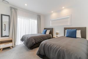 a bedroom with two beds and a window at 19 Broadway in Martinborough