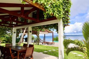 a pergola with a table and chairs and the ocean at The Namele Villas in Port Vila