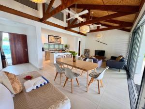 a dining room and living room with a table and chairs at The Namele Villas in Port Vila