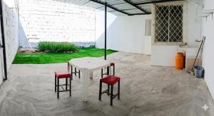 a white table and two red chairs in a room at El delfín Santa Elena -Salinas in Santa Elena