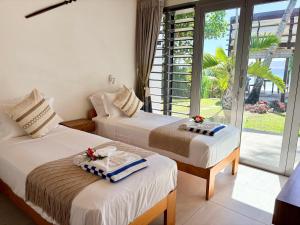 two beds in a room with a window at The Namele Villas in Port Vila +33 photos