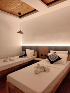 two beds sitting in a room with at Sand 1 Hostel in Siquijor