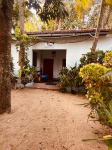 a white house with a porch and a yard at KR Villa in Arugam Bay