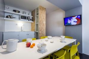 a kitchen with a white table and yellow chairs at Résidence LE VARET - ARC 2000 - Ski-in Ski-out in Bourg-Saint-Maurice