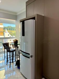 a white refrigerator in a kitchen with a table at Apto novo prox Parque Thermal e centro de evento in Piratuba +23 photos