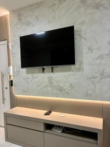 a flat screen tv on a wall in a room at Apto novo prox Parque Thermal e centro de evento in Piratuba