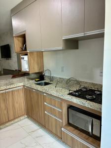 a kitchen with a sink and a stove top oven at Apto novo prox Parque Thermal e centro de evento in Piratuba