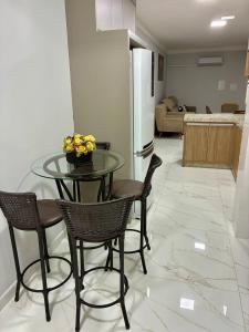 a table and chairs in a living room with a kitchen at Apto novo prox Parque Thermal e centro de evento in Piratuba