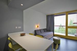 a living room with a table and a couch at Résidence LE VARET - ARC 2000 - Ski-in Ski-out in Bourg-Saint-Maurice +6 photos