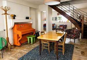 a living room with a table and a piano at Grand gîte convivial proche de Dijon in Marey-sur-Tille