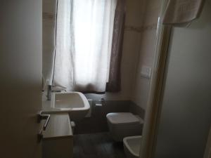 a bathroom with a sink and a toilet and a window at Hotel Moderno in Grumello del Monte