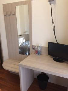 einen Schreibtisch mit einem TV und einem Spiegel in der Unterkunft Twelve Hotel in Moncalieri