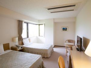 ein Hotelzimmer mit zwei Betten und einem Fernseher in der Unterkunft Seto Park Hotel in Seto