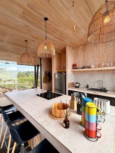 a kitchen with a large table with chairs and pendant lights at Gran Casa con Vista Increíble, Tinaja y WiFi in Cobquecura