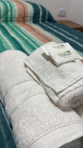 a pile of towels sitting on top of a bed at Apartamentos Villa Jardin in Reyes +29 photos