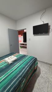 a bedroom with a bed with a flat screen tv on the wall at Apartamentos Villa Jardin in Reyes
